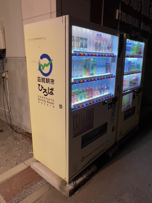 「函館朝市ひろば」のロゴがラッピングされた自販機